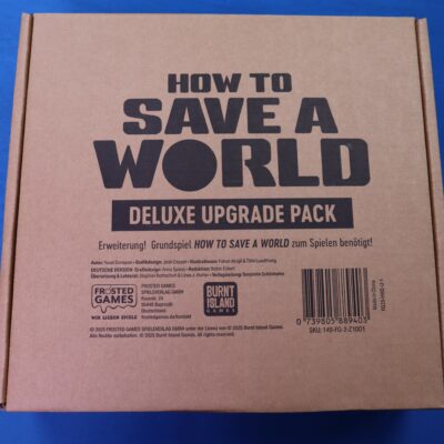 Ein brauner Karton mit dem Text "How To Save A World: Deluxe Upgrade Pack" in schwarzer Schrift. Der Karton ist eine Erweiterung für das Grundspiel und enthält Details zu Autoren, Grafikdesignern und Illustratoren. Am unteren Rand befinden sich Logos von Frosted Games und Burnt Island Games sowie ein Barcode. Der Hintergrund ist blau.